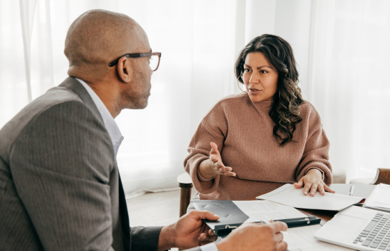 A man and woman are engaged in a discussion, highlighting a collaborative work atmosphere.